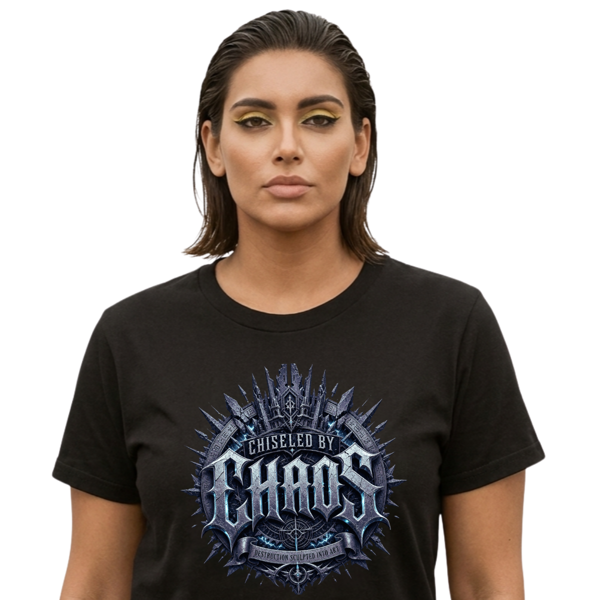 Female model with slicked-back dark hair and gold eyeshadow standing against an isolated white background, wearing a premium black graphic streetwear t-shirt featuring a detailed ice-blue and iron Chiseled By Chaos graphic by Essentia Collective.