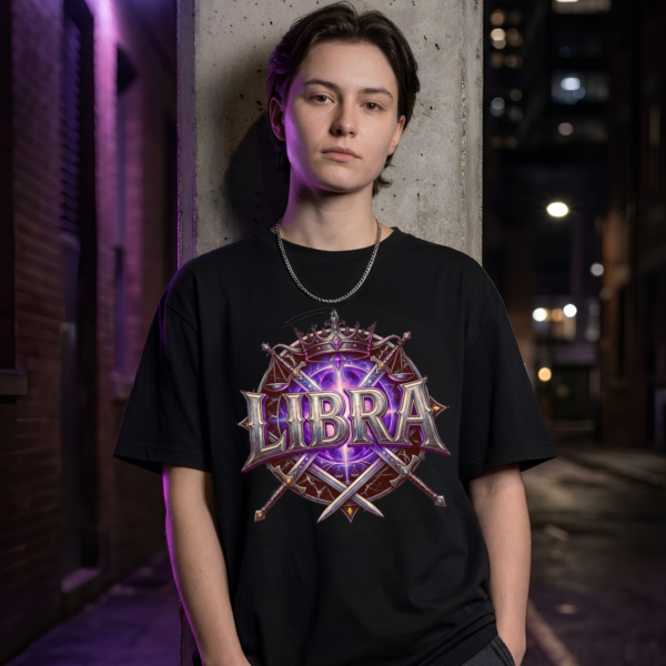 Libra Crown Graphic Streetwear Black T-Shirt Model leaning against a concrete pillar wearing a premium black graphic streetwear t-shirt featuring a detailed Libra crown, scales, and blades design by Essentia Collective.