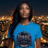 Made Not Given Graphic Streetwear T-Shirt Blue Variant female model with long flowing dark hair at night overlooking a blurred city skyline bokeh, wearing an Essentia Collective premium vibrant blue streetwear graphic t-shirt featuring a metallic Gothic crown crest with the text Made Not Given.