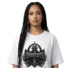Studio portrait mockup of a female model with long micro-braids on a clean white background, wearing an oversized white Essentia Collective graphic streetwear t-shirt with a prominent black and silver gothic emblem reading No Shortcuts.