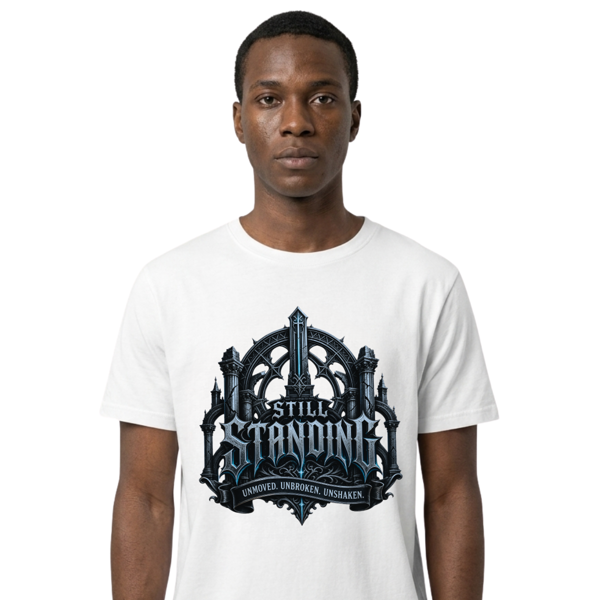 Studio portrait mockup of a male model on a clean white background, wearing a premium white Essentia Collective graphic streetwear t-shirt with a detailed silver and ice-blue gothic cathedral emblem reading Still Standing.