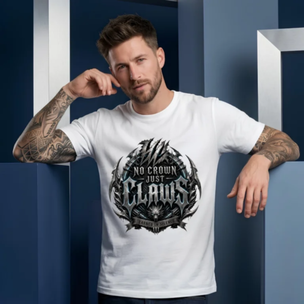 Tattooed male model leaning back against blue and silver geometric column pillars, wearing a white Essentia Collective graphic streetwear t-shirt with a large chiseled silver gothic emblem reading No Crown Just Claws.