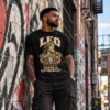 Male model wearing a black Leo zodiac graphic T-shirt in a graffiti-covered urban alley.
