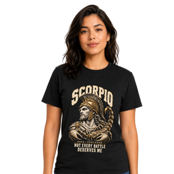 Female model wearing a black Scorpio zodiac graphic T-shirt featuring gold-toned Ares-inspired mythology artwork.