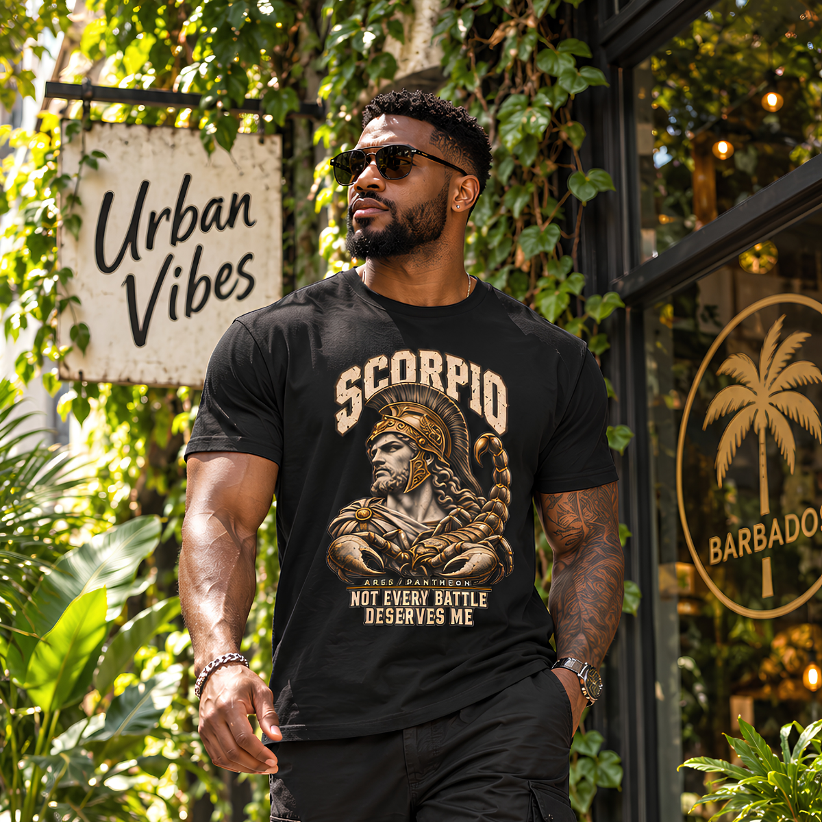 Male model wearing a black Scorpio graphic T-shirt in a sunlit urban setting surrounded by greenery.
