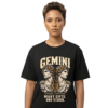 Female model wearing a black Gemini zodiac graphic T-shirt featuring gold-toned Apollon-inspired mythology artwork.
